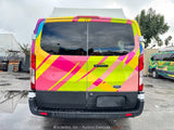 Brightly wrapped Ford Transit van, a unique rv rental option with bold geometric patterns in pink, yellow, and blue.