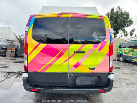 Brightly wrapped Ford Transit van, a unique rv rental option with bold geometric patterns in pink, yellow, and blue.