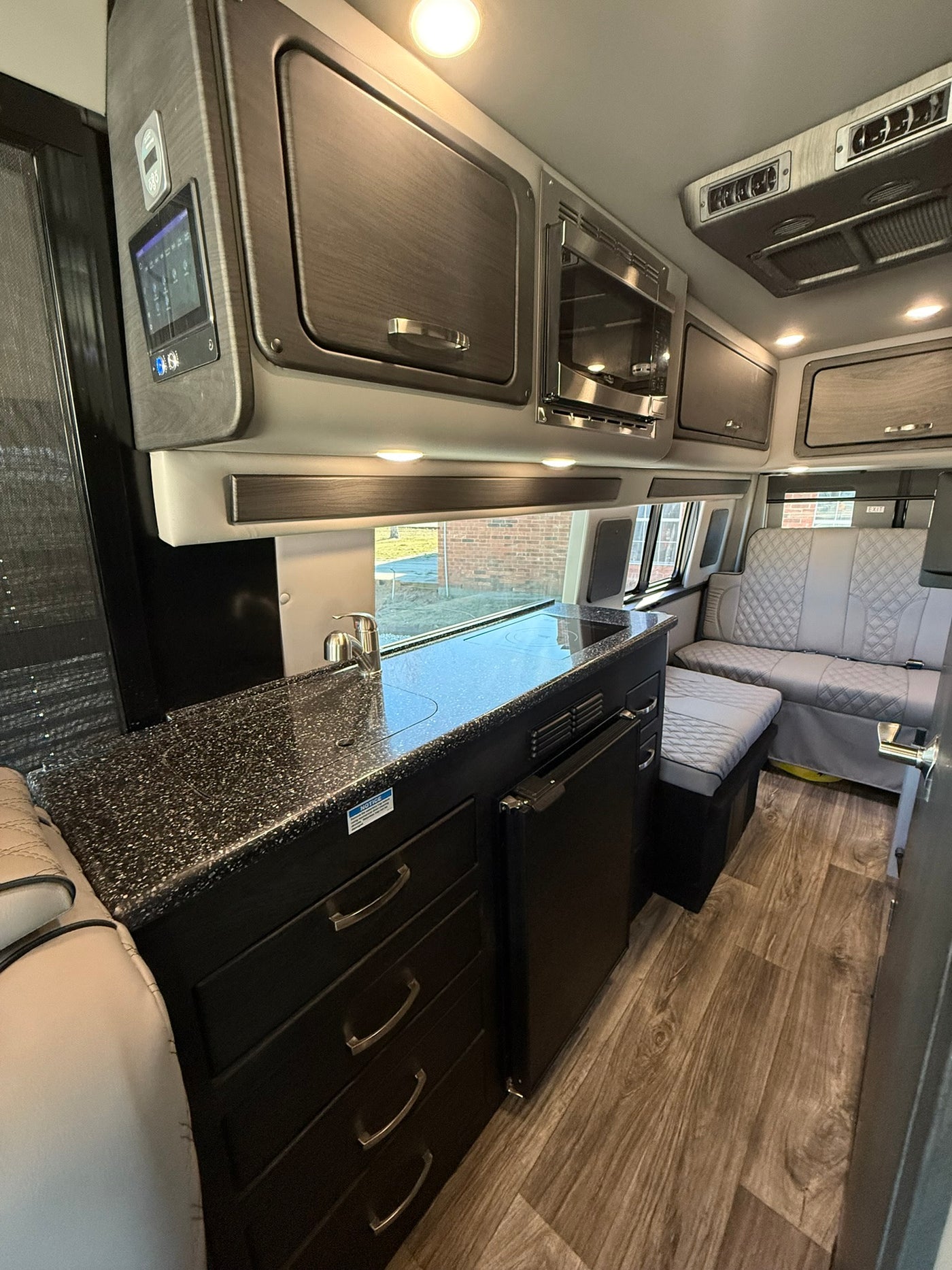  and comfortable rear seating visible.|Luxurious diamond-stitched captain's chairs in a premium rv rental — photo 6