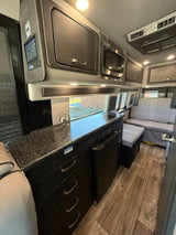 Inside this upscale rv rental, discover a modern kitchenette, smart controls, and cozy quilted seating for your next road trip.