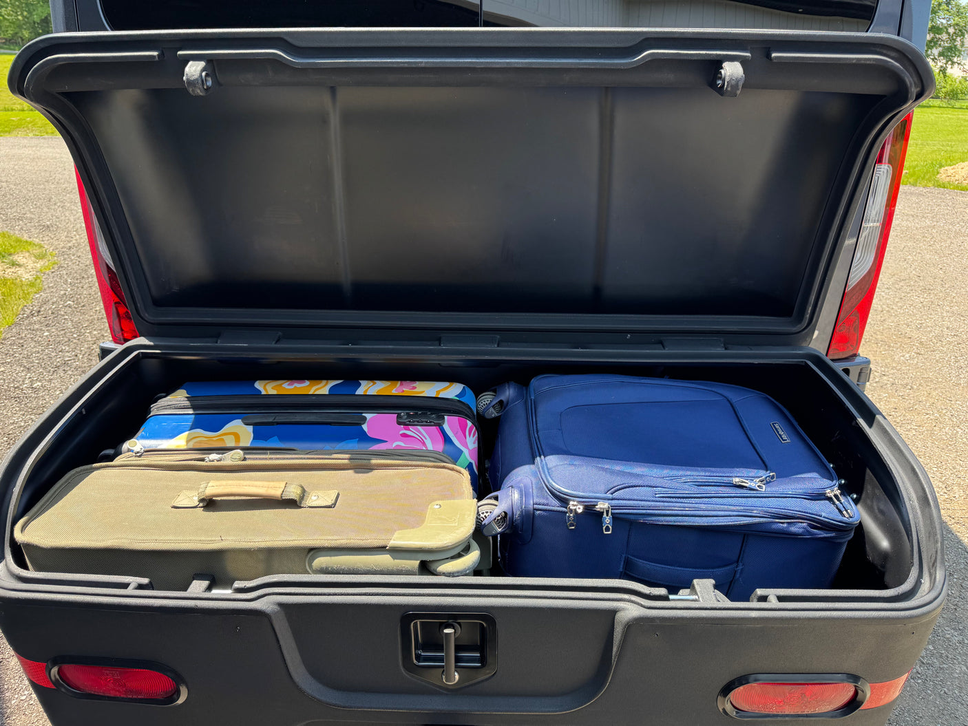 This RV rental cargo carrier, open and packed with travel luggage, is ready for adventure.