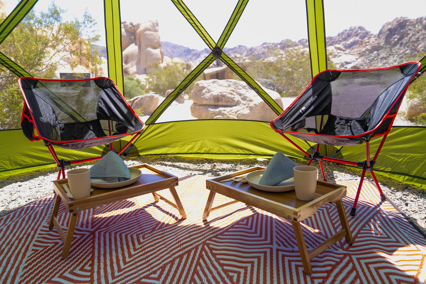 Luxury glamping experience in the desert: two chairs, trays, and stunning views. Enhance your rv rental journey here.
