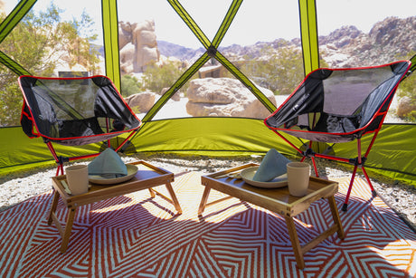 Luxury glamping experience in the desert: two chairs, trays, and stunning views. Enhance your rv rental journey here.