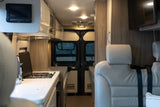 RV rental: Modern interior featuring a kitchen with stovetop, comfortable passenger seating, and TV.