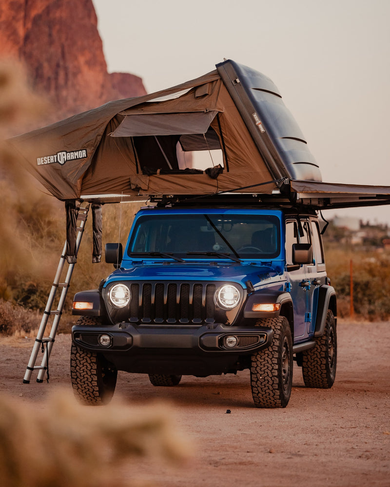 A blue Jeep Wrangler with a Desert Armor rooftop tent deployed, ladder extended. Great for an RV rental off-road camping adventure. — photo 7