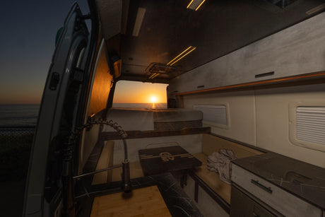 Enjoy van life! This luxurious RV rental offers stunning ocean sunset views from its modern, well-appointed interior.