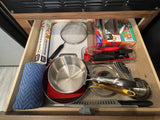 Well-organized RV rental kitchen drawer with cookware, utensils, and essentials like foil and storage bags, ready for use.