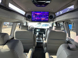 Experience an RV rental's luxury interior, featuring comfortable seating and a large TV screen for ultimate travel entertainment.