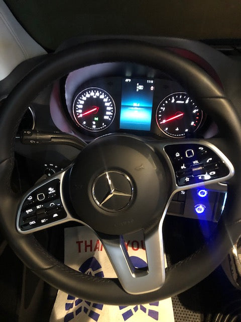 Close-up of a Mercedes-Benz RV rental's interior: steering wheel, instrument cluster with digital display, and illuminated controls. — photo 6