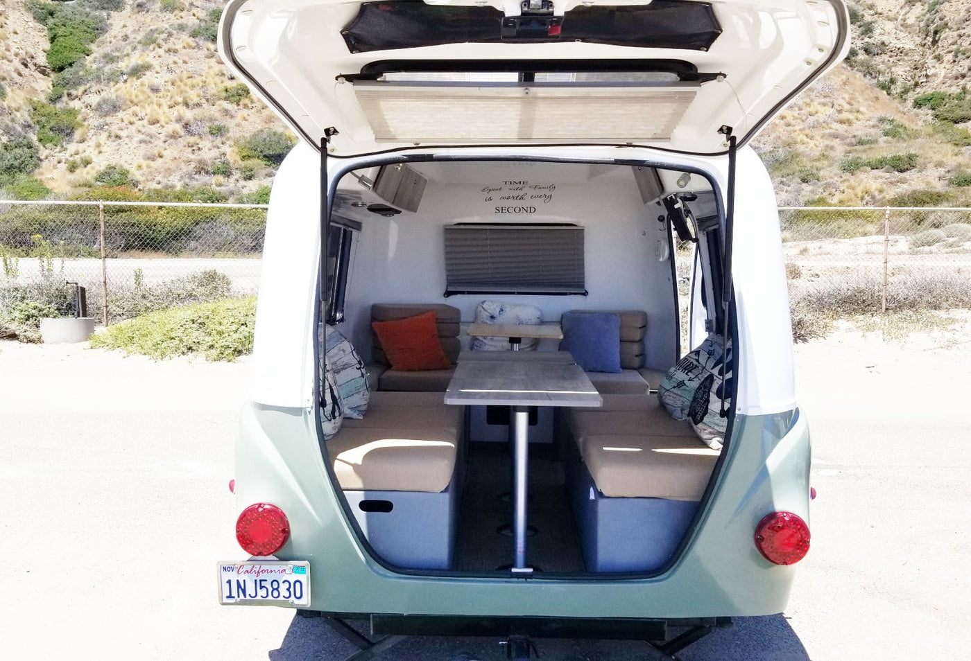 Inside a compact rv rental: open rear hatch reveals a cozy dinette, ready for your next road trip adventure. — photo 11