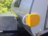 Closeup of an RV rental with a bright yellow protective bumper/grab handle and a diamond plate storage box.