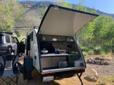 Enjoy a scenic RV rental camping trip! This teardrop camper's open kitchen is ready for adventure in the mountains.