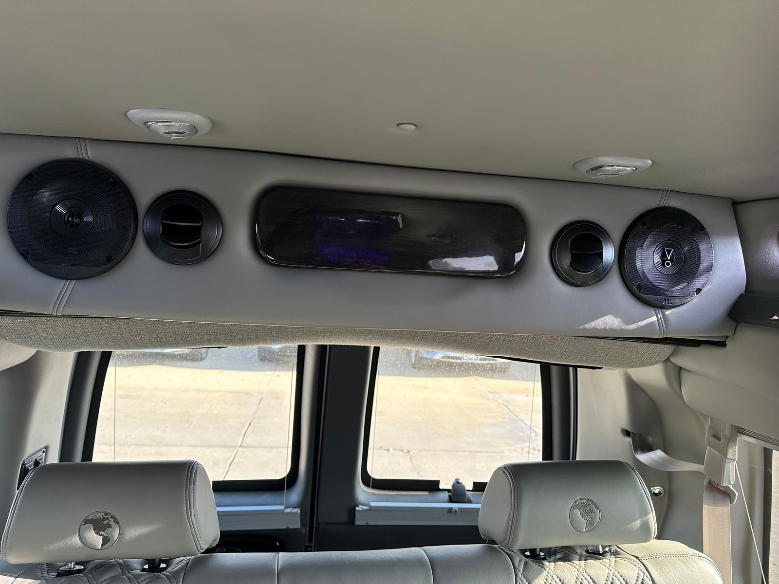Spacious RV rental interior: featuring premium JBL speakers, comfort seating with globe headrests, and cabin amenities.
