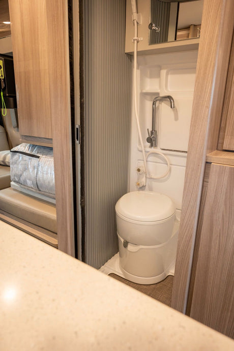 Inside an RV rental: a functional wet bath with an integrated toilet and shower for convenient road trips.