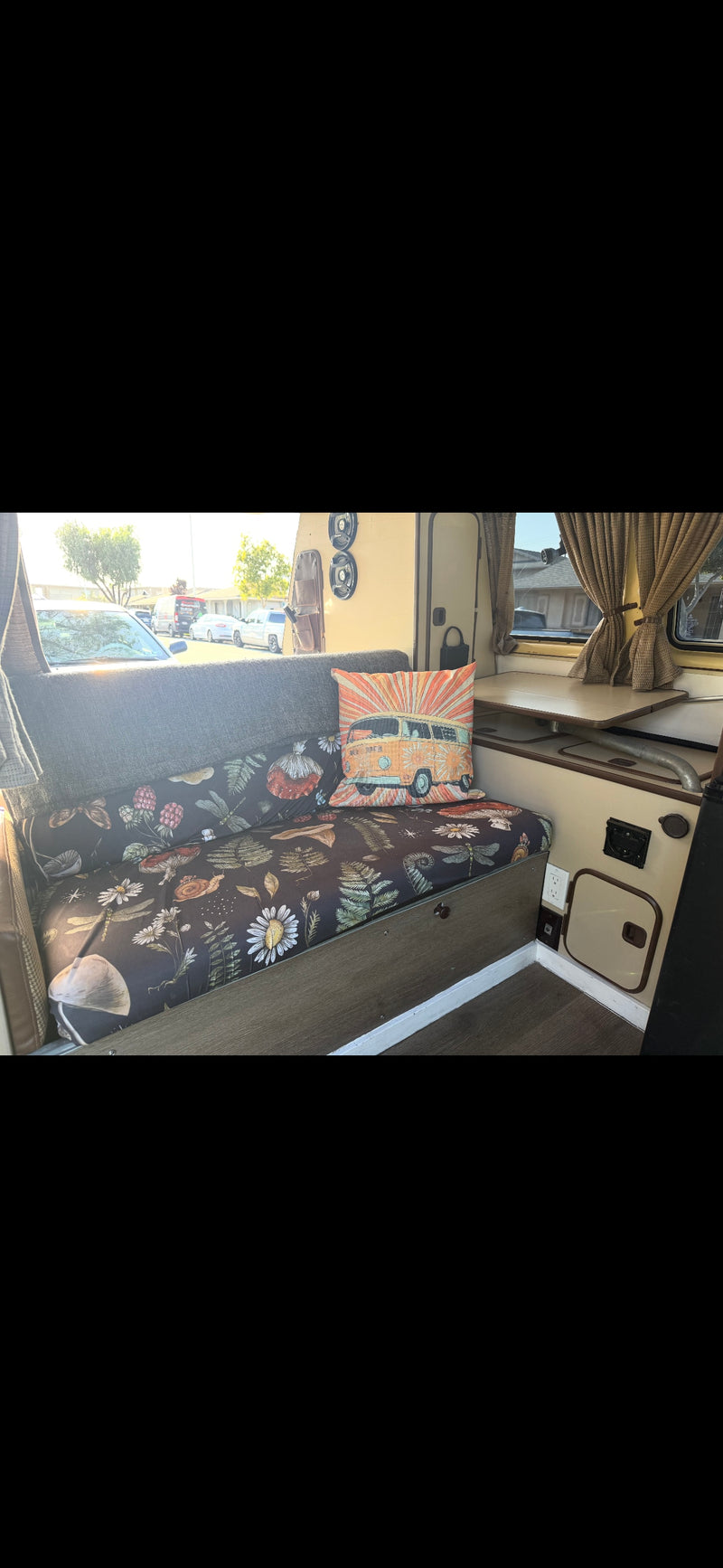 Comfortable RV rental interior: floral bench cushions, a vintage VW van pillow, and a cozy dining area. — photo 2
