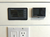 RV rental: Renogy battery monitor (99% charged), Webasto heater control, and an outlet on a white panel wall.