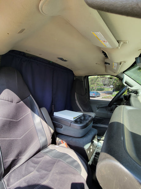 Interior of an RV rental: front cabin with custom privacy curtains, comfortable seats, and a center console.