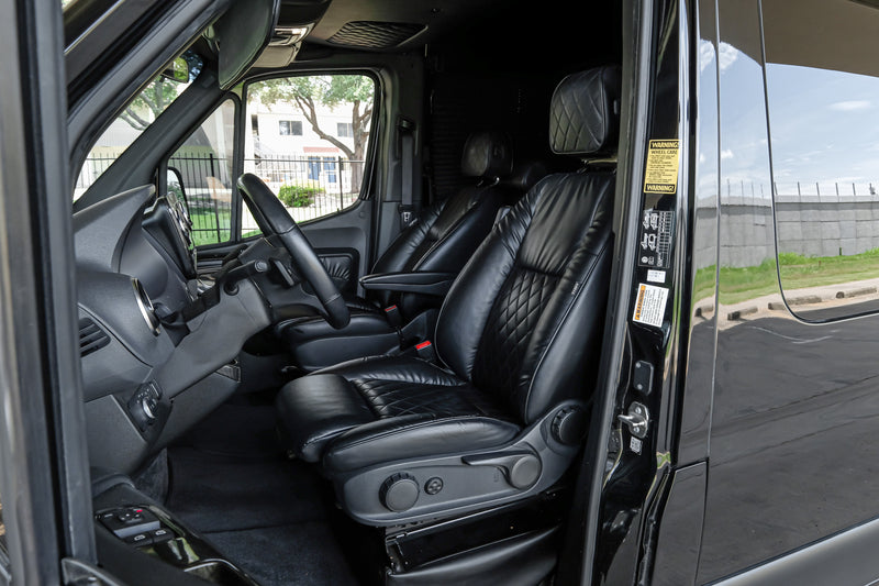 Step into this RV rental's luxurious black leather interior, featuring quilted seating, driver's controls, and a comprehensive dashboard. — photo 5