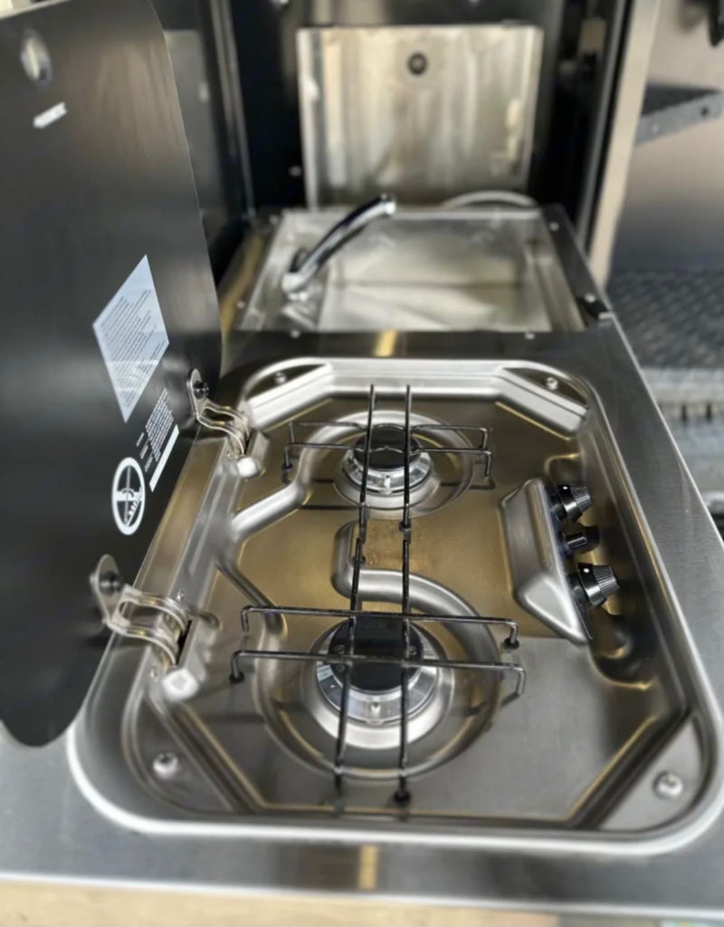 This compact stainless steel kitchenette, featuring a two-burner stove and sink, is perfect for an RV rental adventure. — photo 9