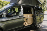 Open side door of an rv rental camper van, revealing its custom wooden interior & extended pop-top roof.