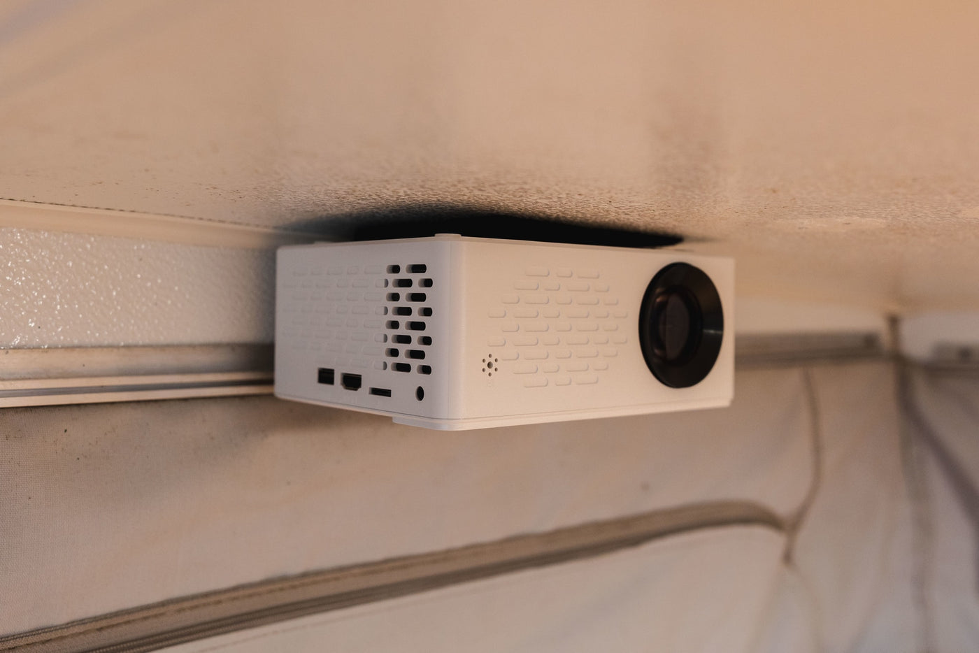 A small white projector, ceiling-mounted in an RV rental, offers on-the-go entertainment. — photo 8