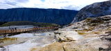 RV rental vacationers explore Yellowstone's stunning Mammoth Hot Springs: mineral terraces, steaming pools, and a scenic boardwalk.