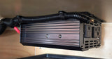 Power inverter, neatly wired under a shelf, providing outlets for RV rental electronics and reliable power connection.