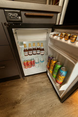 This rv rental mini-fridge is fully stocked with bottled drinks, colorful sodas, and water, ready for your adventure.