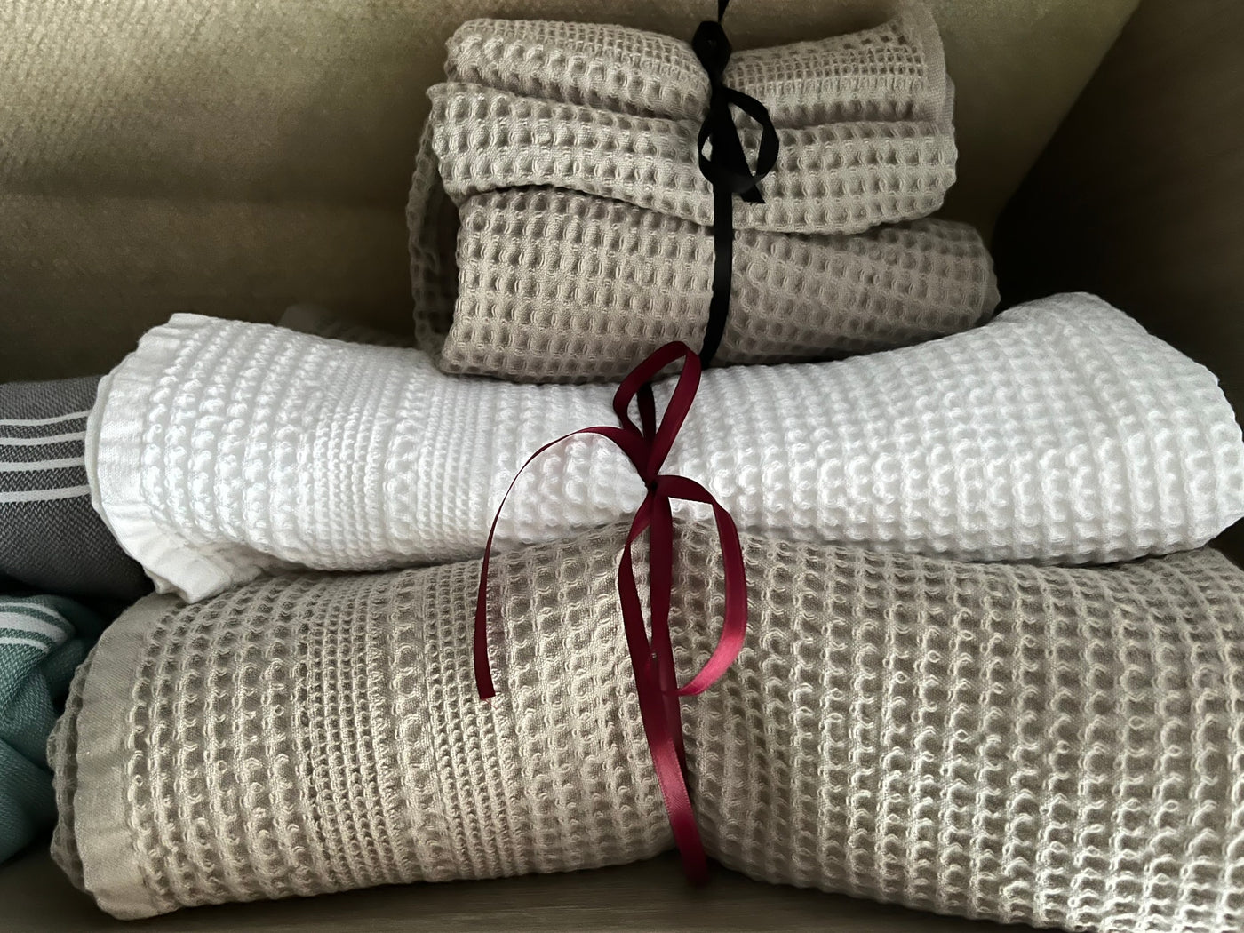 Neatly folded white and beige waffle-weave towels, tied with ribbons, ready for your comfortable RV rental trip. — photo 7