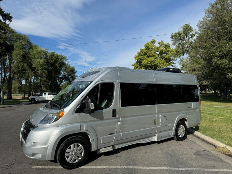  parked on asphalt with trees & blue sky on a sunny day.|Silver Roadtrek camper van — photo 2