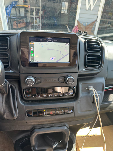 Inside an RV rental: a dashboard with Google Maps on its navigation screen. Climate controls, USB ports, and a Starlink box are visible.
