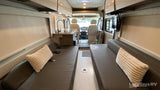 Inside this rv rental: Compact kitchen, twin benches for seating/beds, and front cockpit view.