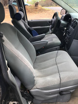 Spacious light gray interior of an RV rental showing the front and second-row seats, dashboard, and steering wheel.