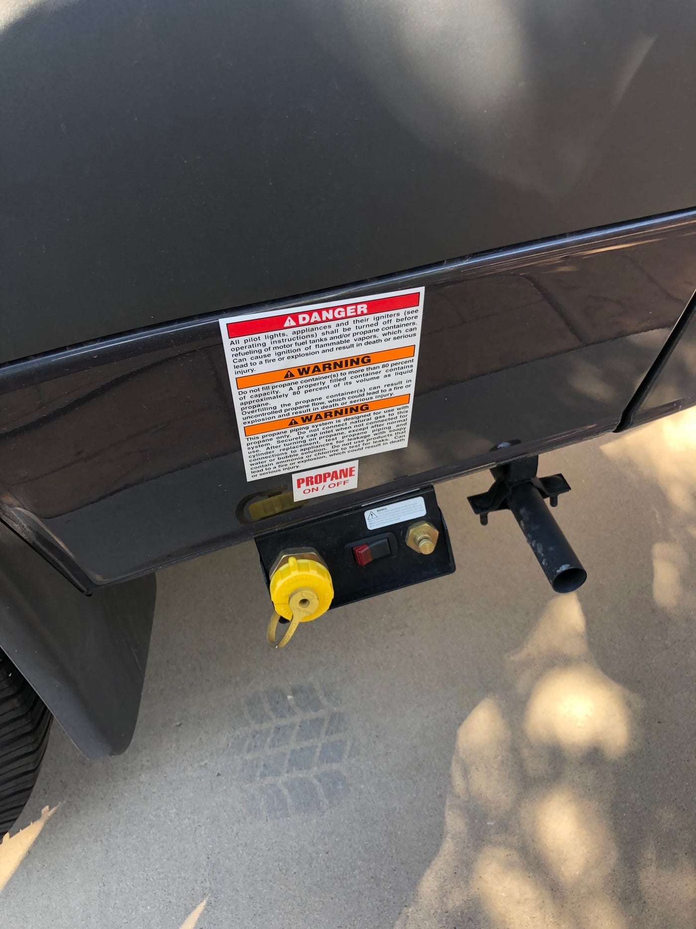  awning extended. Campfire burns beside a picnic table in a pine forest.|Propane connection panel on an RV rental — photo 2