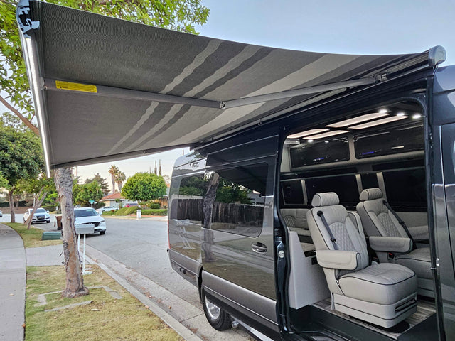 Luxury RV rental van with an extended awning, bright LED lights, and a premium, well-appointed interior.