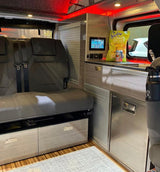 Inside this RV rental: a versatile seating, compact kitchen, mini-fridge, & digital controls for comfortable mobile living.