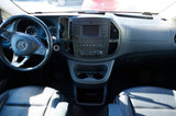 Dashboard and front cabin of a Mercedes-Benz RV rental. View shows steering wheel, infotainment, and functional storage.