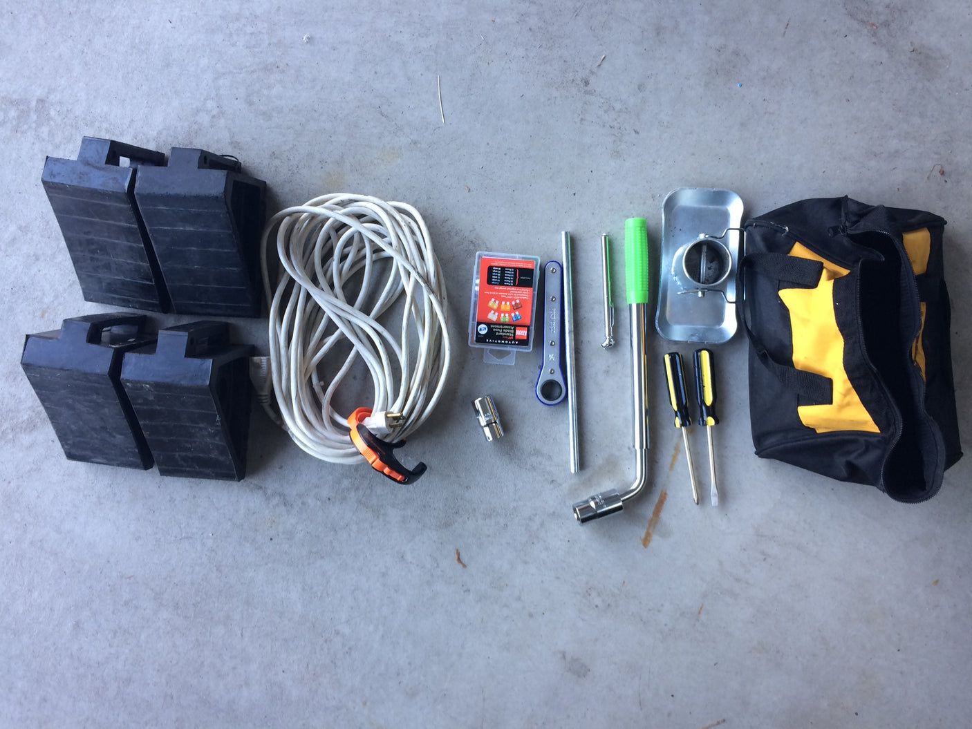 RV rental accessories: tool bag, screwdrivers, lug wrench, fuses, extension cord, and leveling blocks.