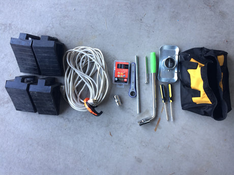 RV rental accessories: tool bag, screwdrivers, lug wrench, fuses, extension cord, and leveling blocks.