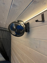 RV rental interior: A clip-on fan (Koonie) and hook on paneled walls, with LED lighting and mesh netting for comfort.