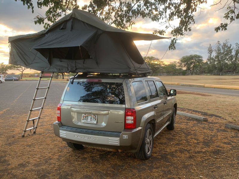Tan Jeep Patriot with roof-top tent and ladder setup at sunset. Perfect for an RV rental or car camping adventure. — photo 19