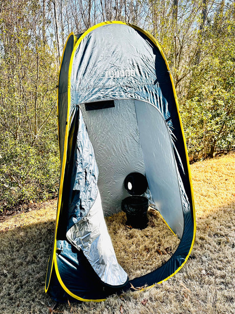 Grey & yellow privacy tent with portable toilet, perfect for your rv rental outdoor adventures or camping.