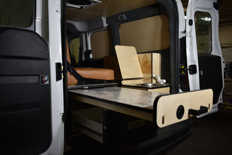 This RV rental shows a clever van conversion interior: a pull-out table, sink, ample storage with a Dometic unit, and seating. — photo 2