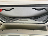 Overhead view in an RV rental reveals a pop-top ceiling with handles, lighting, and accessible storage cubbies.