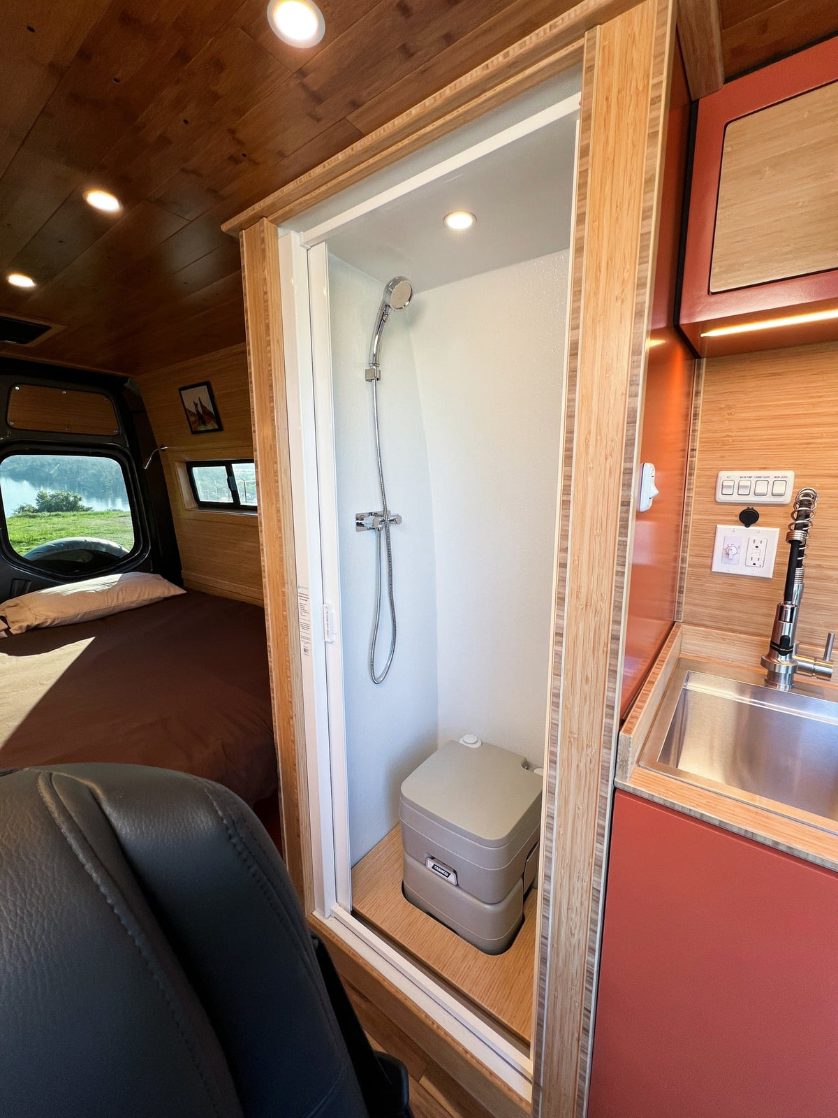  and an open drawer revealing cutlery and a cutting board.|Stylish RV rental kitchen features bamboo countertops — photo 20