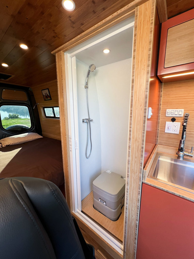 and an open drawer revealing cutlery and a cutting board.|Stylish RV rental kitchen features bamboo countertops — photo 20