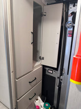 This RV rental's organized interior features an open cabinet, drawers, and compact storage for road trip essentials.