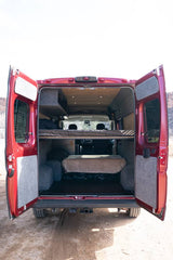 Rear view of a red rv rental camper van with open doors, revealing a cozy two-tier bunk bed interior.