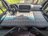 RV rental van's front cabin transformed into a sleeping space with a gray Luno air mattress, perfect for a camper road trip.