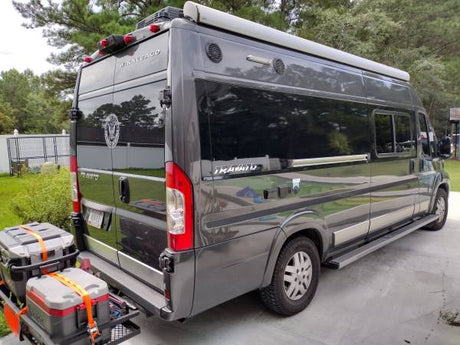 Grey Winnebago Travato camper van with cargo carrier, ideal for rv rental or travel.